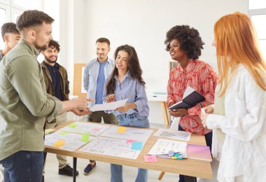 İş adamlarından oluşan bir ekip, ofiste bir toplantı sırasında işbirliği yapar. İş arkadaşları, ortak fikirlerle takım çalışmasını ve üretkenliği geliştirmek için birlikte çalışarak sohbete dalıyorlar..