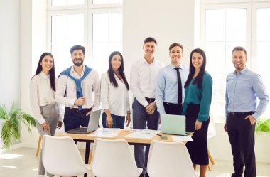 Profesyonel grup lideri ve şirket çalışanları, gülümseyen gençler, ofis yönetim kurulunda başarılı çalışma grubu, kamera, kariyer projesi ve insan kaynaklarına bakan mutlu iş ortakları.