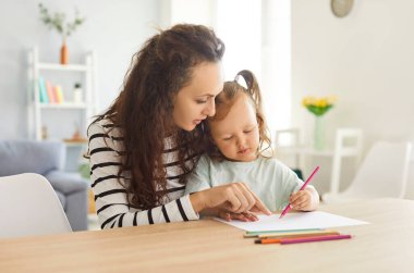 Anne ve kızı evde birlikte yaratıcı vakit geçirmeyi seviyorlar, resim yapıp, resim çizerek aile eğitimi ve boş zamanlarını değerlendiriyorlar. Etkinlik, paylaşılan sanatsal ifade yoluyla bir bağlantı oluşturur.