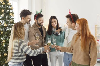 Bir grup arkadaş yılbaşını ya da Noel 'i bir partide şampanyayla kutlar. Kutlama neşeli atmosferi vurguluyor, kadehler sevinçle şıngırdıyor ve bayram neşesiyle.