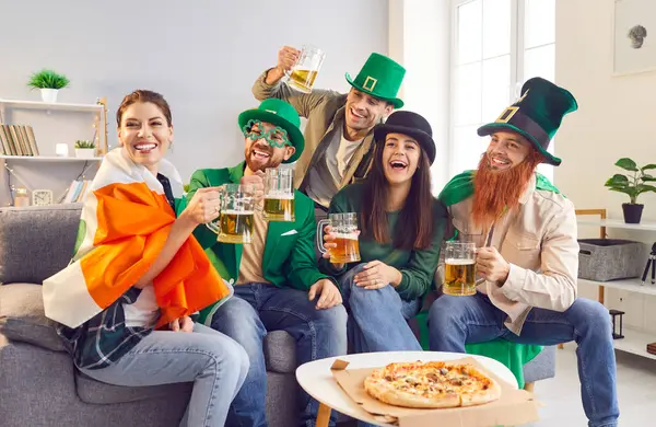 Bir grup mutlu, neşeli, güler yüzlü leprikon şapkalı, yonca şekilli gözlük ve İrlanda bayrağı Aziz Patrick Günü 'nü kutluyor, parti veriyor, bira içiyor, pizza yiyor, eğleniyor.