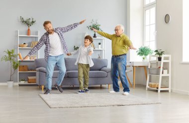 Mutlu üç neslin erkekleri, büyükbabaları, babaları, oğulları eğlenceli oyunlar oynarlar, tatlı, heyecanlı babalar uçakları taklit ederler, eğlenceli oyunlar oynarlar, birlikte eğlenirler, babalar gününü kutlarlar.