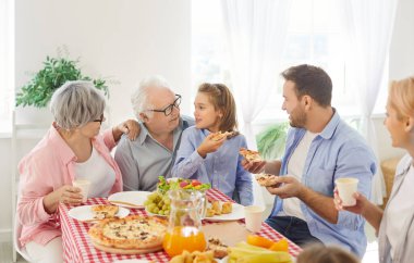 Farklı nesillerden gelen büyük bir aile bir sürü yemekle masada oturuyor, yemek yiyor ve genç bir çocuğun bir hikaye anlatmasını dinliyor. Ebeveynler ve çocuklar yemek odasında öğle yemeği yiyorlar..