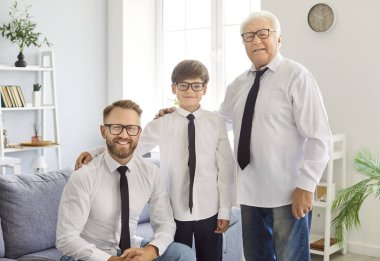 Üç nesildir yakışıklı olan aile büyükbaba, baba, oğul, torun aynı resmi giyip babalar gününü kutlamak için aile içi benzerlikleri gösteren gözlük takıyor. 