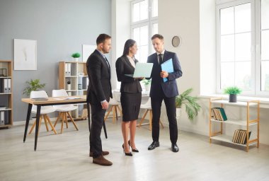 İş arkadaşları bir ofis toplantısında işbirliği, iletişim ve üretkenliği vurgulayarak tartışma ve takım çalışmasına giriştiler. Profesyonel insanlar ortak hedeflere doğru birlikte çalışırlar..