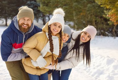 Kış mevsiminde gülümseyen aile kar portresi, Noel 'de orman doğası macerası, yeni yılda aktif tatil eğlencesi, aile eğlencesi fikri, dışarıda birlikte tatil yapmak.