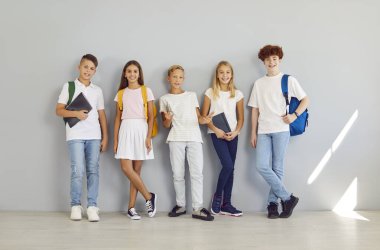 Okul arkadaşlarının portresi, bir grup gülümseyen öğrenci poz veriyor, mutlu öğrenciler. Öğrenciler, liseli kızlar, eğitimli ergenler, okul çantalı okul arkadaşları, ders çalışmaktan zevk alan gençler.