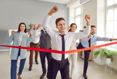 İş dünyası lideri girişimci ofiste yarış düzenliyor. Kararlı mutlu koşucu bitiş çizgisine ulaşıyor. Personel tezahürat yaparken zafer için ellerini kaldırıyor. İş, rekabet, başarı kavramı