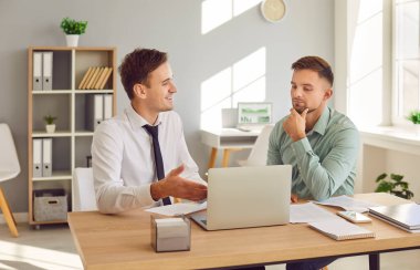 İş adamı adayla ya da bir müşteriyle iş görüşmesi yapıyor. Sahne, HR tartışmalarının ve profesyonel ofis ortamındaki istemci etkileşimlerinin özünü yakalar.