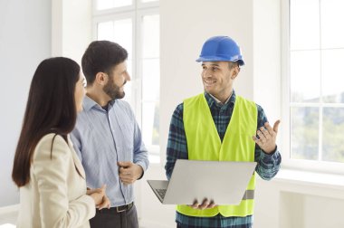 Foreman, bir dizüstü bilgisayardaki ev yenileme projesinin planlarını gözden geçirmek için karı koca ile iş birliği yapıyor. Tartışma, gelecekteki yaşam alanının takım çalışmasını ve ayrıntılı planlamasını vurguluyor.