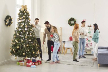 Mutlu gülümseyen insanların tam boy fotoğrafı. Oturma odasında konuşan arkadaşlar. Yeni yıl partisinde toplanan haberleri ve hikayeleri paylaşıyorlar. Noel ve kış tatili konsepti.