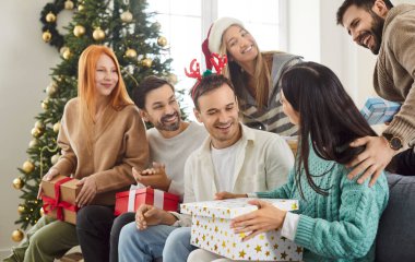 Arkadaşlar yeni yıl ya da Noel partisinde hediye alışverişinde bulunup, kutlama ve hediye verme ortamı yaratıyorlar. Tatil neşesi, toplantıyı sıcaklık ve dostlukla doldurur..