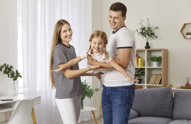 Anne, baba ve kız evde birlikte oynuyorlar, boş zamanların tadını çıkarıyorlar. Sevecen aile bağları oyun ve sevgi yoluyla, rahat bir ortamda mutlu anılar yaratır..