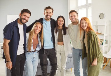 Sıraya dizilip birbirine sarılan beş mutlu, destekleyici genç arkadaşın, öğrencinin ya da meslektaşının grup portresi. Neşeli bir grup insan kameraya bakıyor ve grup fotoğrafı çekiyor..