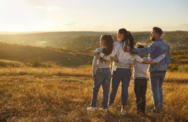 Mutlu aile birlikte doğanın arka plan portresinin tadını çıkarır. Aileler ve çocuklar birbirlerine yakın dururlar, sevgi, sevgi, sevgi, ilgi gösterirler, güneşe hayranlık duyarlar, haftasonu, macera tatili tatili