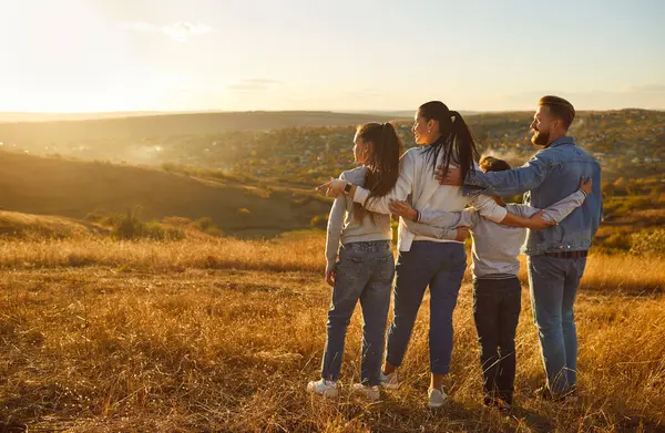 Mutlu aile birlikte doğanın arka plan portresinin tadını çıkarır. Aileler ve çocuklar birbirlerine yakın dururlar, sevgi, sevgi, sevgi, ilgi gösterirler, güneşe hayranlık duyarlar, haftasonu, macera tatili tatili