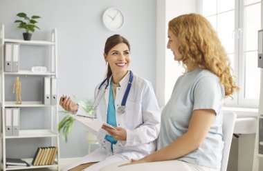 Mutlu gülümseyen kadın terapist profesyonel danışman kadın müvekkil, nazik genç doktor hasta tedavi sonuçlarını paylaşıyor, hastalıkları önleme veya iyileştirme tavsiyeleri, kadın sağlığı