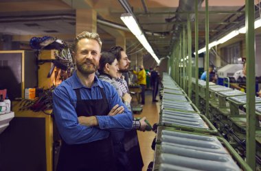 Ayakkabı imalat atölyesinde çalışan mutlu sakallı erkek işçinin portresi. Kitlesel deri ayakkabı üretim endüstrisi kavramı