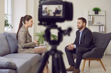 Profesyonel dijital kamera görüntülerini kapatın. Canlı yayında kadın ve erkeğin görüntülerini kaydedin. İki blogger podcaster stüdyoda oturup birbirleriyle canlı video çekiyorlar..