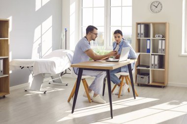 Kendini işine adamış bir doktor, hastane ofisinde bir hastayla, dizüstü bilgisayar ve teknolojiden yararlanan bir tıbbi konsültasyona giriyor. Tıbbi tavsiyelerde bulunmak ve kişisel sağlık çözümlerini tartışmak.