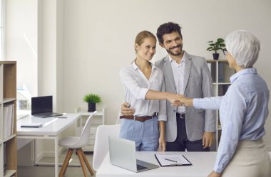 Müşteriler banka müdürüyle el sıkışıyor. Birkaç müstakbel ev alıcısı emlakçıyla tokalaşıyor. Konsültasyon toplantısı için kredi danışmanına mutlu aile teşekkürleri. Boşluk arkaplanı kopyala