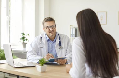 Hasta hastane ofisinde bir doktor ya da hemşireyle tıbbi konuları tartışır. Muayenede, hastanın ziyaret sırasında uygun destek alması için sağlık hizmeti ve rehberlik sunulmaktadır..
