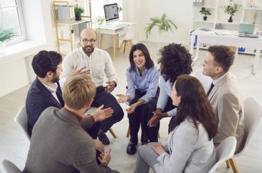 Grup terapi toplantısında konuşan genç bağımlılar, çemberde oturup bağımlılık, zihinsel sağlık sorunları, danışman konuşması, proje için ekibe destek ve tavsiye vermesi, fikirleri paylaşması.