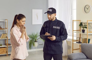 Polis, üniformalı polis memuru kadın kurbanla konuşuyor, resmi form yazıyor. Şüpheliler aranıyor, suç, taciz, soygun, polis soruşturması...