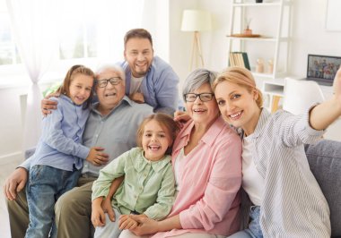Mutlu, büyük bir ailenin portresi. Genç ebeveynler, büyük ebeveynler ve gülümseyen iki çocuk. Kız ve erkek çocuk..
