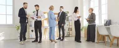 Çiftler halinde toplanan iş adamları, çeşitli şirket grupları, yeni iş fikirlerini başarıyla paylaşıyorlar, kağıt belgeler tutan çalışanlardan oluşan bir ekip, odada birlikte konuşan takım çalışması motivasyonu.