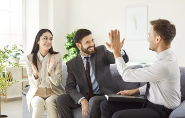 Koltukta oturan ve anlaşmaya sevinen üç genç iş adamından oluşan bir grup greve gitti. İki erkek şirket çalışanı beşlik çakıyor. Diğerlerine toplantıyı bitirmeyi ya da sözleşmeyi imzalamayı öğretiyor..