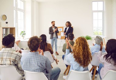 Bir konferans ya da bir grup farklı insan için düzenlenen seminer sırasında bir iş eğitimi üzerine konuşan genç bir adam. Bir grup şirket çalışanı sandalyeye oturmuş ve toplantı odasında alkışlıyorlar..