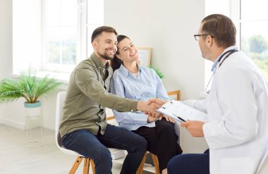Doktor ya da psikolog mutlu hastaları kutluyor, genç çifte danışmanlık, danışmanlık, aile terapisi, kısırlık tedavisi için doğurganlık tedavisi, tıp toplantısına yardım eden destek terapisti