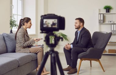 Bir kadın muhabir, bir TV şovu için bir video kamerayla röportaj yapıyor. Röportajlar ve talk şovlar aracılığıyla haber ileten bir halka ilişkiler videosu ya da canlı yayın.