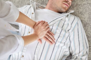 Kardiyopulmoner resüsitasyon ve göğüs masajı yapan, kalp krizi geçiren baygın genç adama dolaylı kalp masajı yapan bir kişi. İlk yardım acil konsepti.