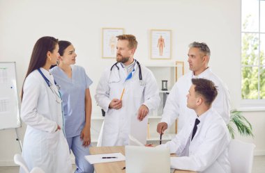 Doktorlar ve hemşireler hastane ofisindeki bir toplantıya ya da konferansa katılacaklar. Grup işbirliği verimli bir sağlık hizmeti ve personel iletişimi sağlar.