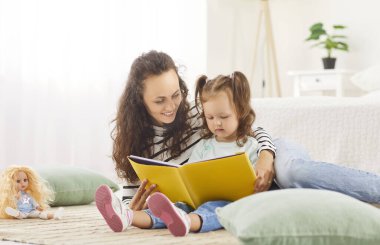 Anne ve kızı evde kitap okuyarak, mutluluk ve aile eğlencelerini paylaşarak kaliteli zaman geçirmekten hoşlanıyorlar. Huzurlu ortam huzur, bağlantı ve edebiyat sevgisini birlikte yansıtır..