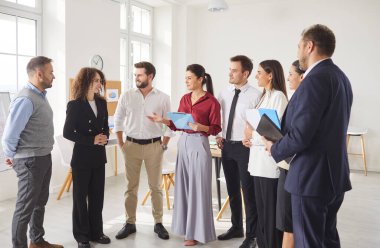İş adamları profesyonel başarıyı gruplandırır, destek sunar, modern ofiste ayakta durur, dost canlısı bir insan kaynakları müdürü ve takım lideri yeni çalışanı karşılar, mutlu çalışmalar, tebrikler.