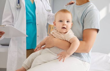 Küçük tatlı bebek hasta ve genç anne klinikteki çocuk doktorunu ziyaret ediyor. Klinikte aile doktoruna danışmanlık sağlık muayenesinden sonra tavsiyelerde bulunuyor.