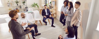 Bir grup farklı iş adamı ofiste toplanırken sohbet ediyorlar. Şirket çalışanları iş projelerini tartışıyorlar ve meslektaşlarını dinliyorlar. Şirket iş ekibi konsepti. Pankart.