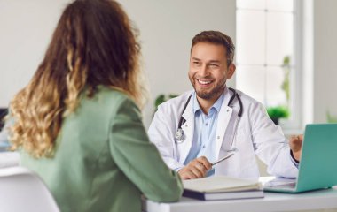 Doktorla sohbet. Dost canlısı erkek doktorun portresi, kadın hastasını muayenehanede dinlemekten mutluluk duyuyor. Sıhhiyeci önündeki kadına bakıyor. Tıp, sağlık ve insan kavramı.