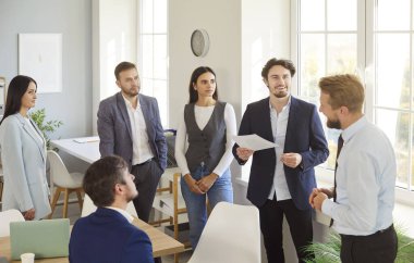 Çağdaş bir ofiste yapılan bir toplantıda altı profesyonelden oluşan bir grup. Meslektaşlar dikkatle dinlerken iki adam bilgi veriyor ve not alıyor..