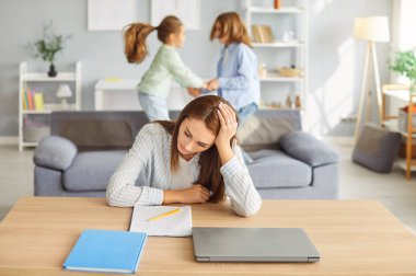 Gürültülü odada genç, yorgun bir kadın, dadı, bebek bakıcısı, bekar anne baş ağrısından muzdarip, komik kız ve oğul bağırarak kanepeye zıplıyorlar, evdeki gürültücü çocuklar kendilerini yorgun hissediyorlar.