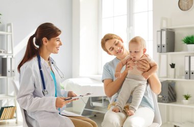 Genç anne ve babası, tatlı bir bebekle oturuyor ve klinikte danışmanlık yapan ve tıbbi muayeneden sonra tavsiyelerini dinleyen gülümseyen dost canlısı çocuk doktoru aile doktoruyla konuşuyorlar..