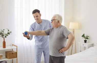 Yaşlı tombul emekli hasta, genç doktor fizyoterapistin ya da doktor bakıcısının yardımıyla kol kasları için fitness halterli rehabilitasyon egzersizi yapıyor. Son sınıf fizyoterapi konsepti
