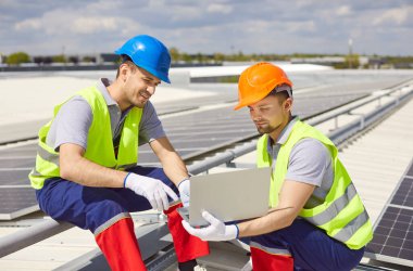 Professional electricians or technicians configuring solar panels on a roof using a laptop. The photovoltaic system generates renewable power, showcasing advanced energy technology. clipart