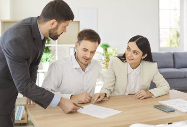 İş arkadaşları çalışma masasında oturmuş yeni projeyi tartışıyor, anlaşmaya varıyor ve anlaşma imzalıyor. Ortaklık ve takım çalışması kavramı.