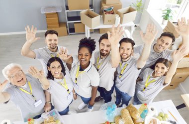 İnsani yardım organizasyonunda ya da bağış merkezinde çalışan çok uluslu mutlu gönüllülerin portresi. Takım çalışmasını ve hayır işlerine ve kamu hizmetine bağlılığı somutlaştırıyorlar..