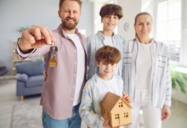 Çocuklu mutlu bir aile, ellerinde yeni bir evin ya da gayrimenkulün anahtarları var. Taşınmanın sevinci ve heyecanı ya da yeni bir yere taşınmanın ve kendi mülküne sahip olmanın heyecanı, yeni bir başlangıç ve yeni bir başlangıcı simgeliyor..