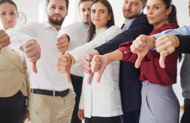 Ofiste bir araya gelmiş ciddi profesyonellerden oluşan bir grup, hepsi baş parmak işareti yapıyor. Genç iş adamlarından oluşan bir ekip memnuniyetsizlik ya da hoşnutsuzluğu ifade ediyor, hoşnutsuzluk ve reddetme gösteriyor..